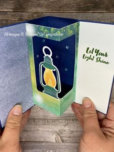 someone is holding an open card with a lantern on it, and the inside of the card reads let your light shine