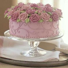 a pink cake sitting on top of a table next to a sign that says decorating cakes