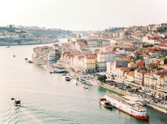 boats are in the water next to some buildings on the side of a body of water