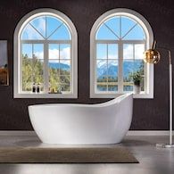 a large white bath tub sitting in front of three windows