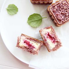 three pastries on a white plate with green leaves