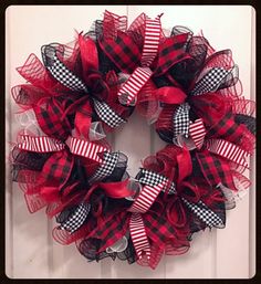 a red and black wreath on the front door with white stripes, checkered bow