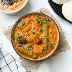 two bowls of soup on a white table