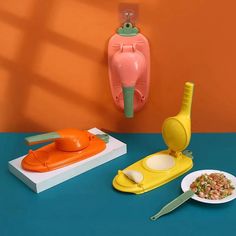 an assortment of kitchen utensils and plates on a blue table with orange walls