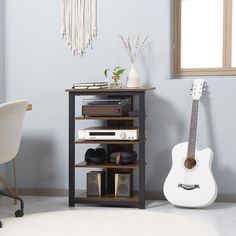 a room with a chair, guitar and other items on the shelf next to it