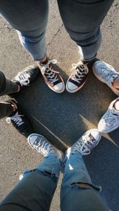 four people standing in a circle with their legs crossed