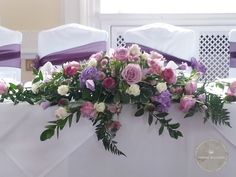 the table is set with purple and white flowers