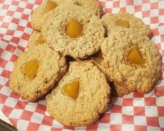 several cookies with peanut butter on top sitting on a checkered table cloth