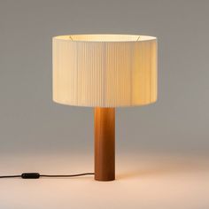 a lamp that is on top of a white surface with a cord attached to it