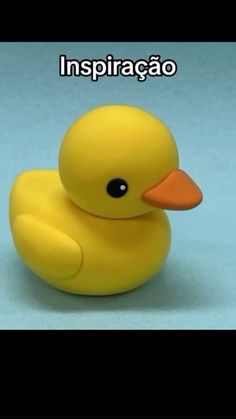 a yellow rubber ducky sitting on top of a blue surface with the caption inspiracao