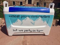 a blue and white cooler sitting on top of a sidewalk