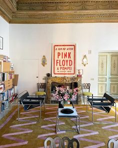 a living room filled with furniture and a fire place next to a book shelf full of books