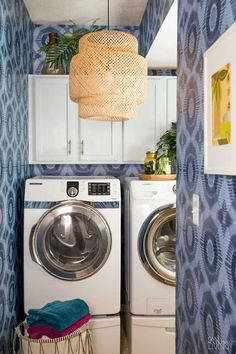 a washer and dryer in a room with blue wallpaper on the walls