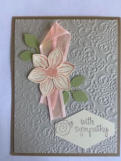 a close up of a card with a flower on the front and an embellishment in the back