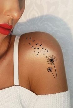 a woman with a dandelion tattoo on her shoulder and red lipstick is looking at the camera