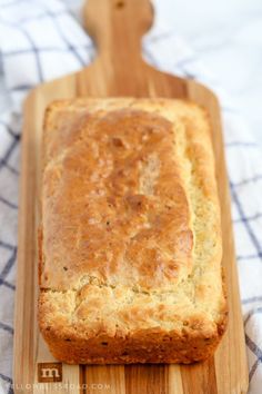 a loaf of bread sitting on top of a wooden cutting board