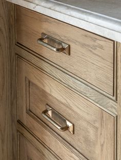 a wooden dresser with marble top and brass pulls on it's drawer handles,