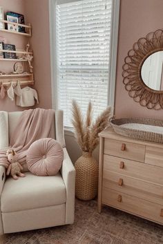 a baby's room with pink walls and furniture