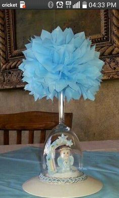 there is a glass vase with a blue flower in it on top of a table