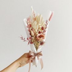 a hand holding a bouquet of flowers on a white background