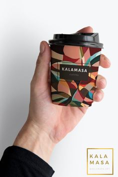 a hand holding a coffee cup with kalamasaa on the sleeve and lid