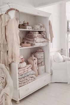 a white shelf filled with lots of different types of cloths and other things on top of it