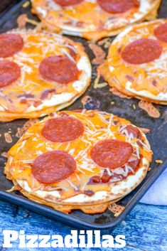 mini pizzas with cheese and pepperoni on a baking sheet