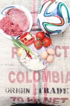 a table topped with plates and bowls filled with meat, veggies and eggs