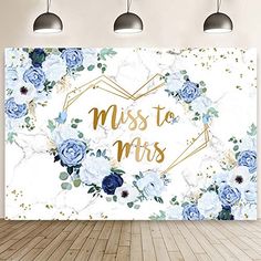 a white wall with blue flowers and the words miss to mrs in gold foil on it