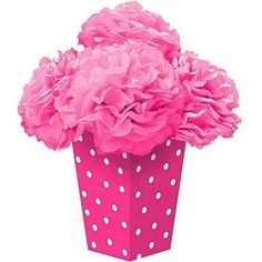 a pink vase with white polka dots on it and flowers in the center is filled with tissue pom - poms