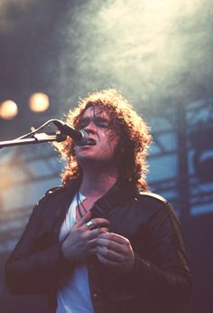 a man standing in front of a microphone on stage