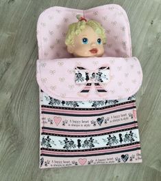 a baby doll in a pink purse on the floor