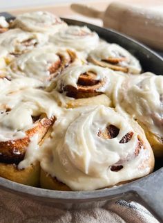 cinnamon rolls in a pan with icing on top