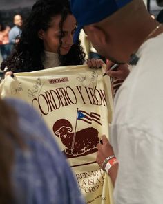 a woman holding up a sign that says ordero y leon with an american flag on it