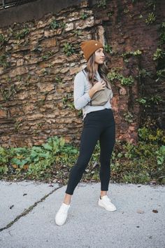 ashley wearing a gray long-sleeved tee, black leggings, white sneakers, and brown beanie with an olive green crossbody bag worn over the shoulder standing in front of a rock wall with green plants Belt Bag Outfit Casual, Womens Beanies Outfits, Women Beanie Outfit, Outfit Ideas With Hats, Athleta Outfits, Outfit With Leggings, Belt Bag Outfit, Leggings Outfit Fall, Brown Beanie