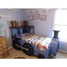 a child's bedroom with a train bed and dresser