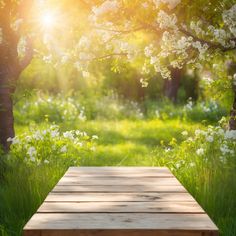 a wooden bench sitting in the middle of a lush green field with white flowers on it