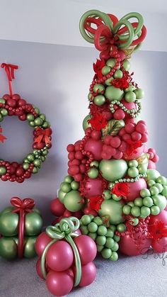 a christmas tree made out of balloons and other items is shown in this image,