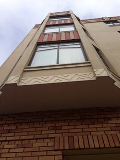 an upward view of a brick building with windows