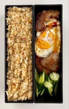 two black containers filled with rice, meat and veggies next to each other