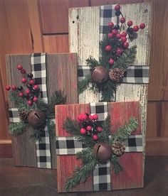 three wooden blocks decorated with christmas decorations and pine cones on the top one is red, black and white plaid