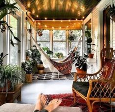 a person laying in a hammock on top of a rug next to a window