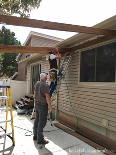 two men are working on the roof of a house while another man is repairing it