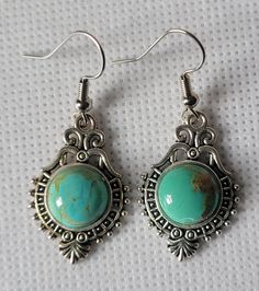 Turquoise holds a special place in Tibetan culture as a symbol of nobility and grandeur, as it relates to the Turquoise-Studded Crown of a long ago Tibetan King!  To date, Tibetan turquoise is highly valued for its beauty and healing properties. It is said that wearing Tibetan turquoise will help preserve liver and eye health.  Turquoise comes in many color  variations, but the blue-green hue only pertains to genuine Tibetan Turquoise, making it a select  jewelry choice. This elegant and chic pair of Tibetan Turquoise earrings will be a perfect choice for adding sophistication and value to your everyday attire. The cabochon is 10mm round, carefully secured on a hand-picked antique silver bezel setting showing a gorgeous and delicate etching design.  Lightweight and discreet (0.21 oz., 1.5i Blue And Silver Earrings, Tibetan Culture, Turquoise Dangle Earrings, Tibetan Turquoise, Turquoise Earrings Dangle, Earrings Elegant, Eye Health, Earrings Blue, Turquoise Earrings