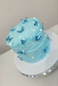 a cake with blue frosting and butterflies on it