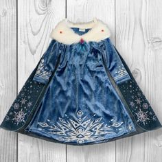 a blue dress with white snowflakes on it and a fur collared neckline