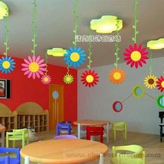 the children's room is decorated in bright colors and has flowers hanging from the ceiling