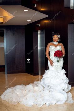 a woman in a wedding dress standing on the floor