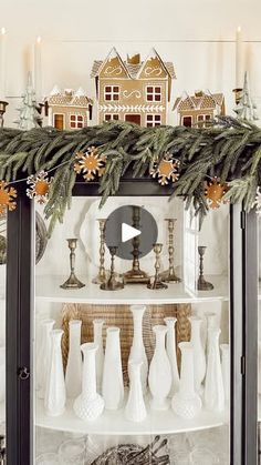 a display case with christmas decorations and candles on it's shelves in front of a mirror