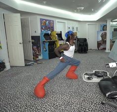 a man is sitting on the floor with his feet in the air and wearing red boots